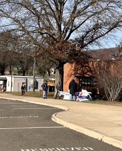 Two tables with signs from Republican and Democratic candidates for Virginia's 10th District outside a high school.