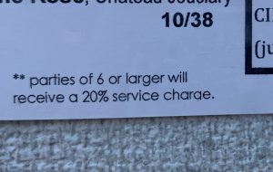 A service charge listed on a menu.